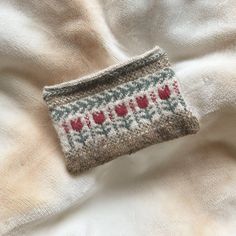 a knitted pouch sitting on top of a white blanket