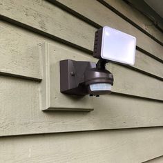 an outdoor security light mounted on the side of a house's exterior wall,