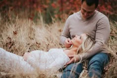 a man sitting next to a woman in a field