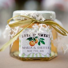 a jar filled with jam sitting on top of a table next to a white ribbon