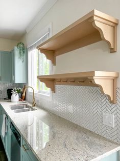 a kitchen with green cabinets and marble counter tops