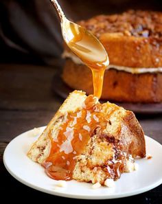 a piece of cake with caramel sauce being drizzled over it on a white plate