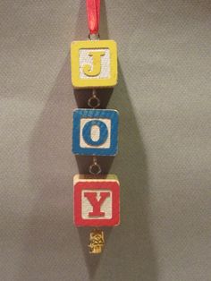 an ornament is hanging on a wall with the word joy spelled in blocks