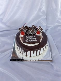 a birthday cake with chocolate icing and cherries on top