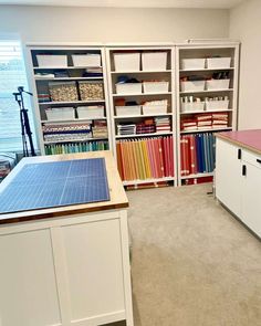 a room with many books and files on the shelves, including binders and folders