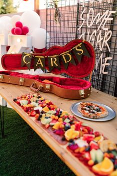 a wooden table topped with a guitar case filled with candy