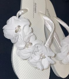 Beautiful Floral Beach Wedding Flip Flops, wrapped in white satin ribbon and decorated with white pearl and  rhinestone flowers. All flip flops are handmade with a production time of one week plus shipping transit time. Please message me if you would like a specific color ribbon or trim. I would be happy to create sandals that fit your individual wedding needs. Pearl White Summer Wedding Shoes, Summer Party Bridal Accessories In White, Summer Bridal Accessories For Bridal Shower, White Summer Bridal Accessories For Bridal Shower, Summer White Bridal Accessories For Bridal Shower, White Bridal Accessories For Summer Bridal Shower, White Pearl Embellished Wedding Shoes For Summer, Elegant White Wedding Shoes For Beach Ceremony, Adjustable White Sandals For Beach Wedding