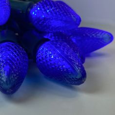 blue christmas lights are arranged on a white surface