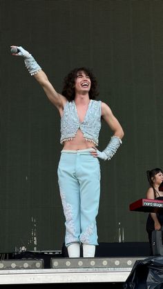 a woman standing on top of a stage with her arms in the air