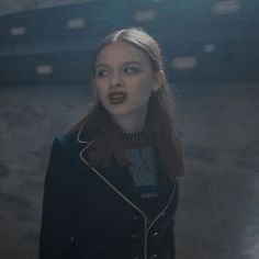 a woman with red lipstick standing in an empty room