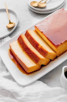 slices of sliced bread on a white plate with sauce and spoons next to it