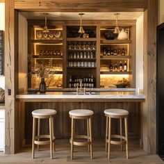 the bar has three stools in front of it and shelves with bottles on them