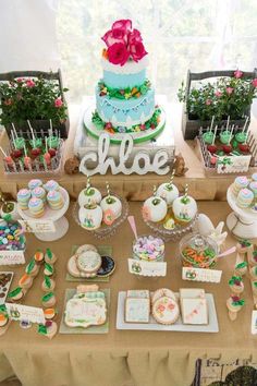 a table topped with lots of cakes and cupcakes