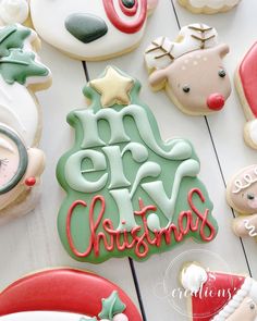 decorated christmas cookies on a white table with merry lettering and ornaments around them, including a santa clause or snowman