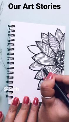 a woman's hand drawing a sunflower on top of a notebook with the words our art stories