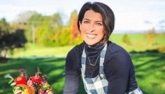 a woman sitting on top of a bike next to a bouquet of flowers in front of her