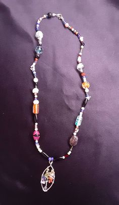 "This necklace  is made of sterling  silver  and glass beads. The pendant is a  colorful  tree of life pendant the colors in the pendant metaphysically reaches the Chakra centers. The beads are a variety  of glass, plastic and shell, citrine, laborite, jasper and amethyst. This necklace is one of a kind and a duplicate has not been made.  Necklace Measurements: Length: 22\" Pendant  Height: 1.4\" If you have any questions or concerns, please do not hesitate to contact our shop. Thank you for you Spiritual Beaded Glass Jewelry, Spiritual Glass Gemstone Beads Jewelry, Spiritual Glass Beaded Jewelry, Bohemian Glass Beaded Necklace With Natural Stones, Multicolor Spiritual Jewelry With Large Beads, Spiritual Multicolor Jewelry With Large Beads, Spiritual Long Crystal Necklace With Colorful Beads, Spiritual Czech Glass Necklaces With Large Beads, Colorful Glass Beads Festival Jewelry