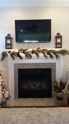 a living room decorated for christmas with stockings and garland on the fireplace mantels