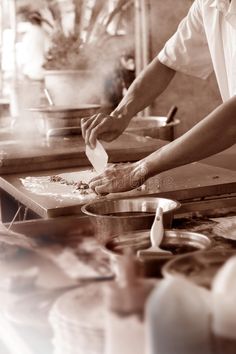 two people are preparing food in a kitchen