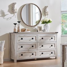 a white dresser sitting in front of a mirror