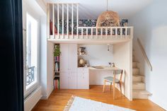 there is a loft bed in the middle of this room with a desk and stairs