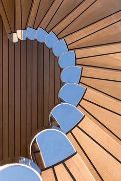 the inside of a wooden structure with blue chairs on it's sides and wood slats in the background