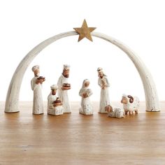 the nativity figurines have been placed in front of an arch with a star on top