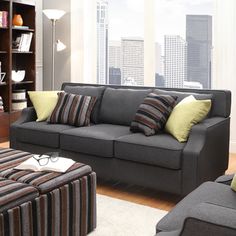 a living room scene with focus on the couch and chair, bookshelf in the background