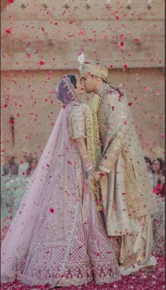 two people standing next to each other in front of confetti