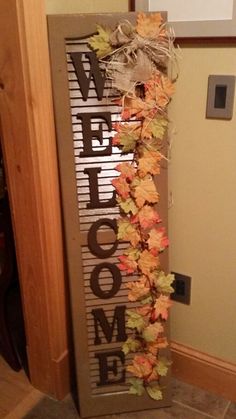 the welcome sign is decorated with leaves and burlucks for fall decorating