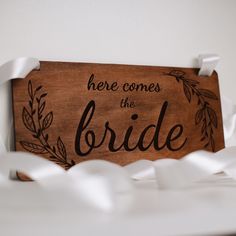 there is a wooden sign that says here comes the bride