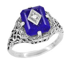 This dramatic Art Deco filigree lapis ring features a lovely emerald cut lapis lazuli gemstone as the background for a securely four prong set shimmering 0.01 round natural single cut diamond in a diamond shaped setting. Sure to be noticed, this beautiful vintage daylight ring replica is crafted in sterling silver pierced filigree and hand finished with intricate detail in a scrolls, flowers, and leaves pattern with an antiqued finish. This original Carolines ring style was purchased directly fr Vampire Ring, Daylight Ring, Thick Silver Ring, Art Deco Filigree, Lapis Lazuli Jewelry, Lapis Ring, Caroline Forbes, Lapis Lazuli Ring, Silver Stacking Rings