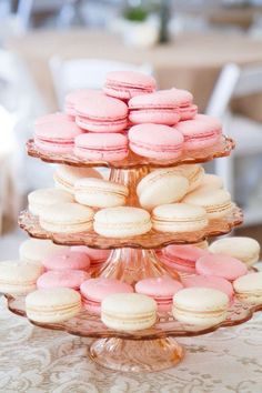 three tiered trays with pink and white macaroons on top of each other