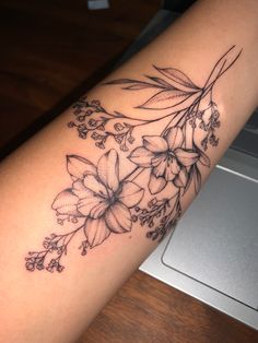 a woman's arm with flowers and leaves tattoo on the left side of her body