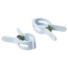 two white plastic clamps with green handles on each side, one is open and the other is closed