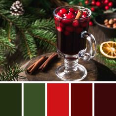 a glass mug filled with hot chocolate and cranberries on top of a wooden table