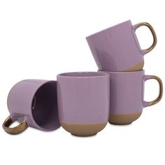 three coffee mugs stacked on top of each other with gold rings around the cups