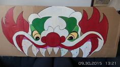 a cardboard box with a clown's face painted on it