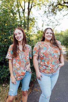 The Leighton Floral Top features a teal base complemented by vibrant orange hue florals. With short sleeves and a v-split neckline, this top is perfect for any occasion. Embrace the happy tone and brighten up your wardrobe with this top. Fits true to size. Model is wearing a small and is 5'6". Plus model is wearing a 1X and is 5'7". Size Chart Length Bust S 24.5" 38" M 25.5" 40" L 26.5" 42" XL 27.5" 44" 2x 27.5" 47" 3x 28" 50" *All measurements are approximate and done while hanging.* Fabric and Vibrant Orange V-neck Top, Vibrant Floral Print Short Sleeve Tops, Orange Vibrant Print Short Sleeve Tops, Orange Floral Print V-neck Top, Tiered Dresses, Plus Model, Teen Dress, Hanging Fabric, Spring Fits