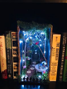 a book shelf filled with lots of books covered in fake plants and trees next to each other