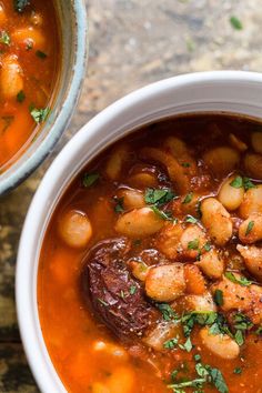 two bowls of soup with beans and meat