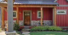 a red house with stone steps leading up to the front door and covered porch area