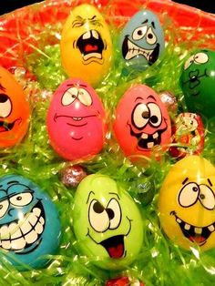 many different colored eggs with faces painted on them