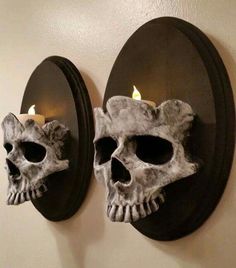 two skulls are mounted to the wall with candles