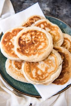 some pancakes are on a green plate with white napkins