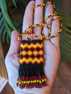 a hand holding a beaded necklace in it's palm