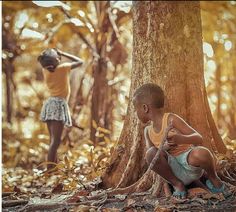 two young boys are playing in the woods