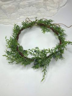 a wreath made out of branches and leaves on a table with laces around it