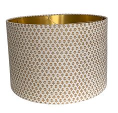 a white and gold lamp shade on a white background