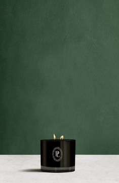 a black candle sitting on top of a white table